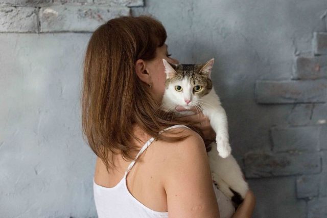 Женщина обнимает кошку